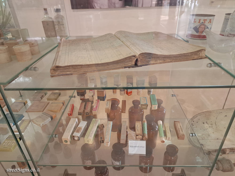 Tel Hashomer Hospital - Display of items from the Mamlock Pharmacy - Tablets for internal use, and on the shelf above - a prescription book (probably from 1959)